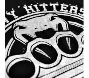 Produktinfo: Made of 100% high grade brazilian cotton, "Heavy Hitters"'s tee shows us some tremendous design with its oversize brass knucles made with silver ink. Amazing result! Technical features : - 100% high grade brazilian cotton. - Very conmfortable. - High quality screen printing. - Silver ink. - Made in Brazil.